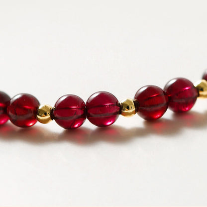 Pulsera Buddha Stones de oro de 14 quilates con flor de cinabrio y granate natural.