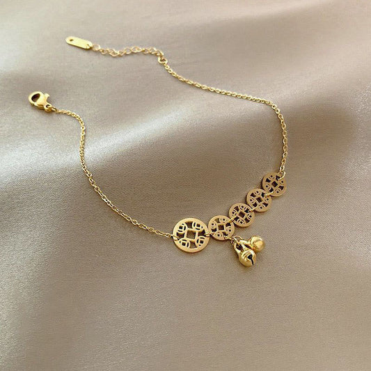 Tobillera reforzada de acero y titanio con dije de campana y monedas de cobre y piedras de Buda