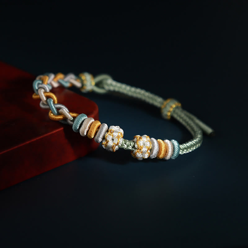 Pulsera de cuatro hilos con piedras de Buda y flor de durazno 