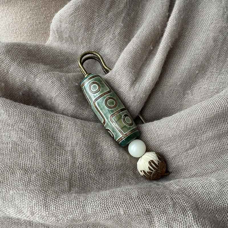 Broche protector de loto con semillas de bodhi y cuentas Dzi de nueve ojos de Buda