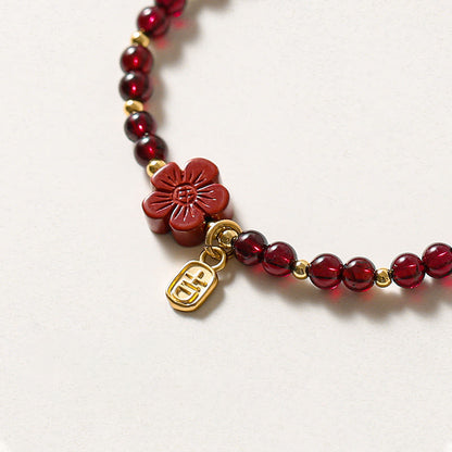 Pulsera Buddha Stones de oro de 14 quilates con flor de cinabrio y granate natural.