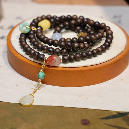 Pulsera de la paz con 108 cuentas de mala de Buda, madera de agar de Brunei, ámbar, ágata roja y jade con hebilla de la paz.