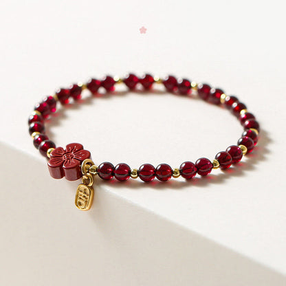Pulsera Buddha Stones de oro de 14 quilates con flor de cinabrio y granate natural.