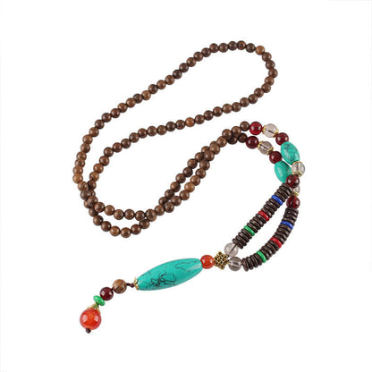 Collar con colgante de piedra turquesa, madera de wengué y piedras de Buda que protegen la calma.