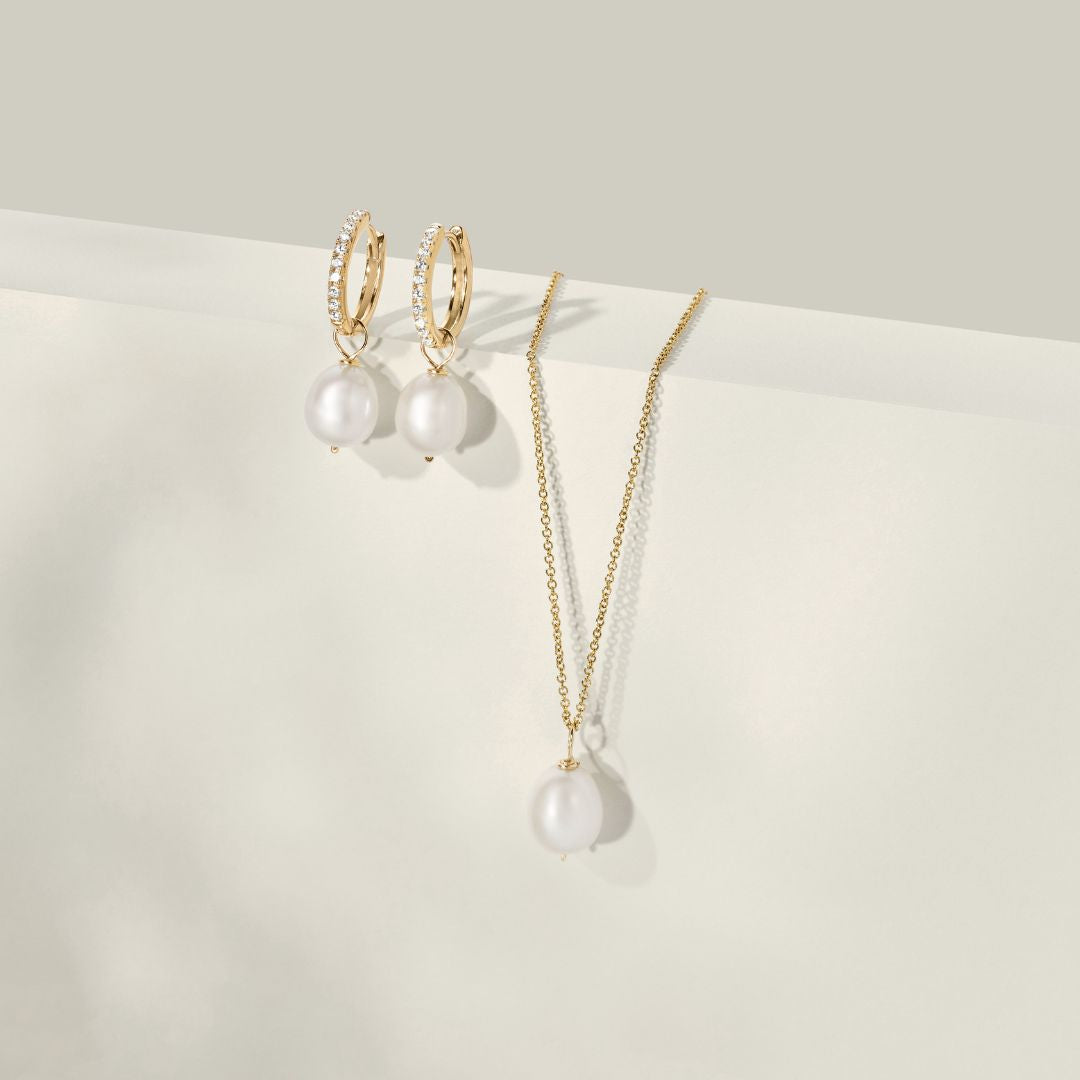 Conjunto de regalo de aros huggies con perla dorada y collar de perlas grandes