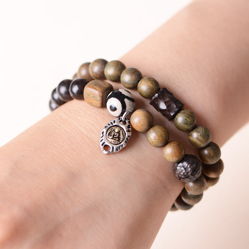 Pulsera de doble vuelta con cuentas Dzi de tres ojos de madera de ébano y sándalo verde tibetano con piedras de Buda y carácter Fu, equilibrio y paz.