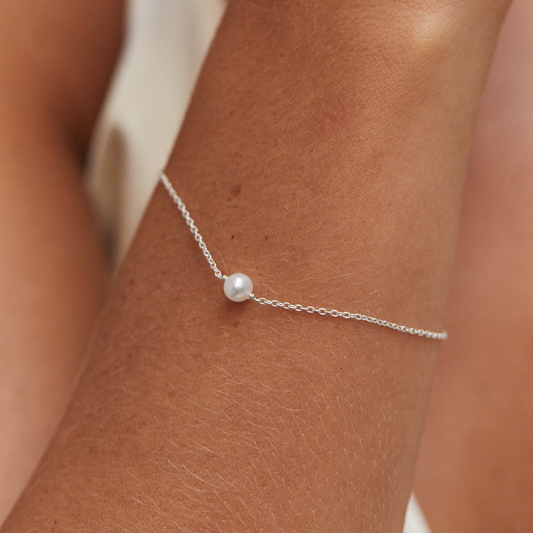 Geschenkset mit silbernen Perlentropfen-Huggies und einem einzelnen Perlenarmband