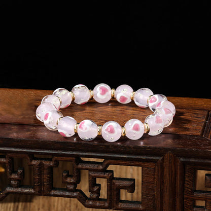 Pulsera de cuentas de vidrio fluorescentes Liuli con corazón de amor rosa y piedras de Buda doradas.