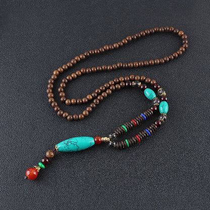 Collar con colgante de piedra turquesa, madera de wengué y piedras de Buda que protegen la calma.
