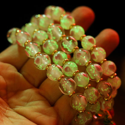 Pulsera con abalorios de cristal fluorescente Liuli con forma de corazón de amor rosa luminoso y piedras de Buda doradas.