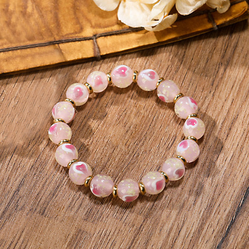 Pulsera con abalorios de cristal fluorescente Liuli con forma de corazón de amor rosa luminoso y piedras de Buda doradas.
