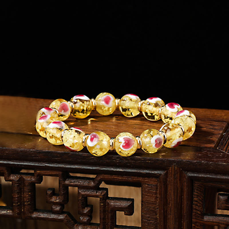Pulsera de cuentas de vidrio fluorescentes Liuli con corazón de amor rosa y piedras de Buda doradas.