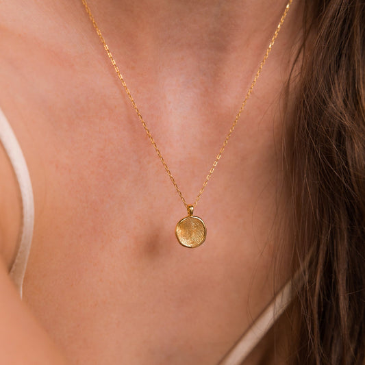 Collar de monedas con huellas dactilares