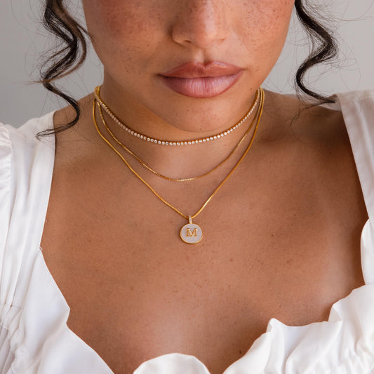 Collar con disco inicial de piedras preciosas